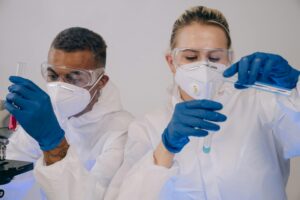 two scientists with masks on working in lab with chemicals